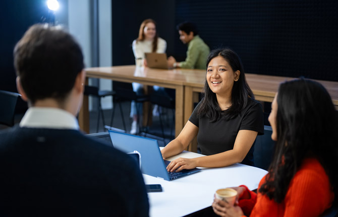 Two international students talking to each other in a classroom